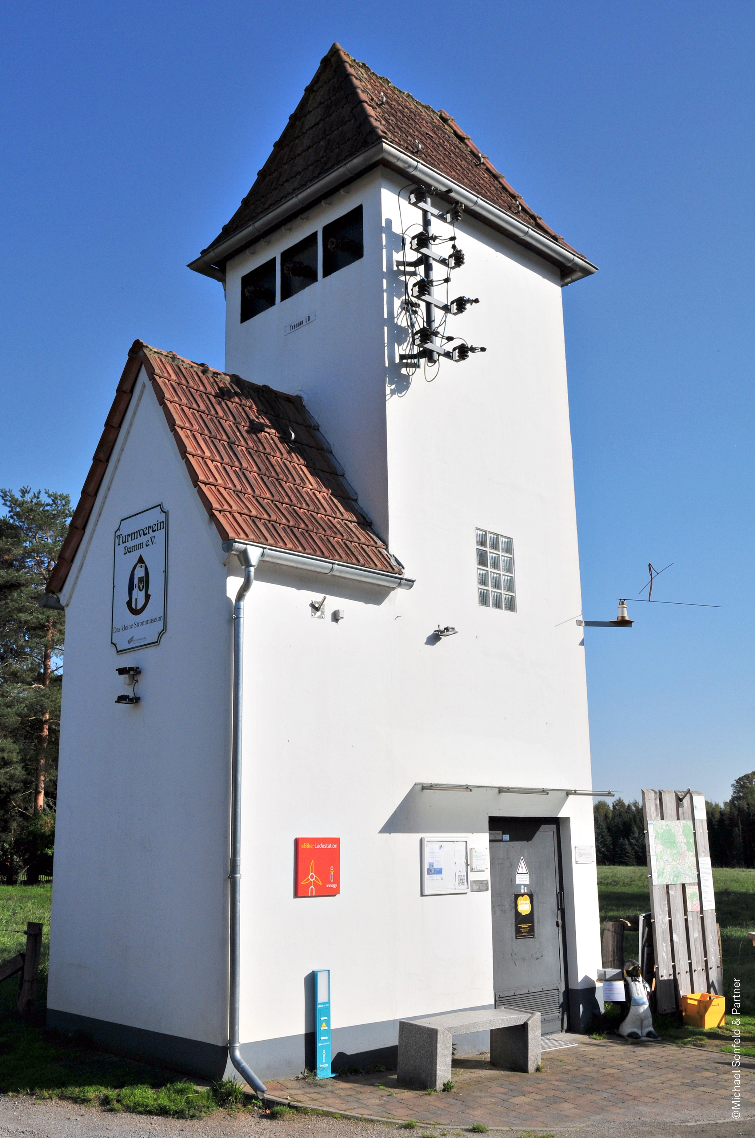 Im Vordergrund steht ein Trafoturm. Der Trafoturm ist renoviert. 